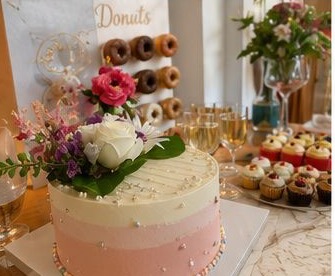 Dessert table with cake, cupcakes, and donut stand